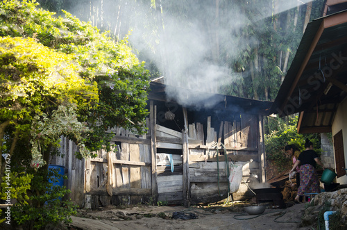 Woman Ethnic Hmong cooking and plucking chickens at outdoor in morning at Doi Pui Tribal Village and National Park