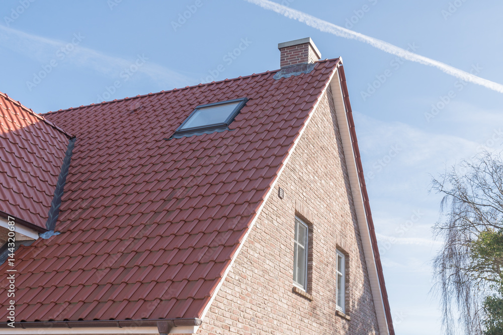 Dach mit einem Dachfenster und roten Dachpfannen Dach mit einem Dachfenster und roten Dachpfannen