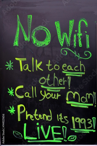 A board in front of the foodmarket  is announcing that there is No WiFi and suggests to talk to each other or call your mom or pretend it’s 1993 or LIVE