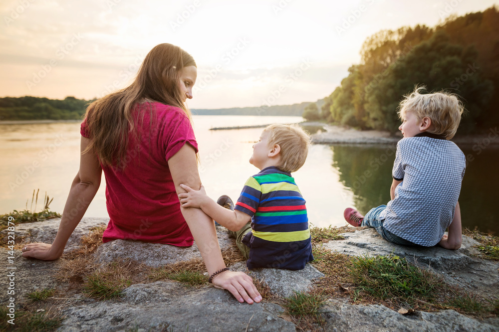 Mother with two sons at the lake, sunny spring day. Mother with two sons at the lake, sunny spring day.