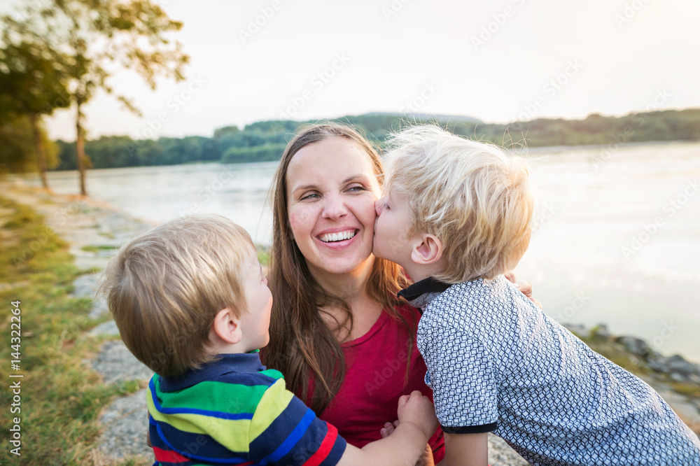 Mother with two sons at the lake, sunny spring day. Mother with two sons at the lake, sunny spring day.