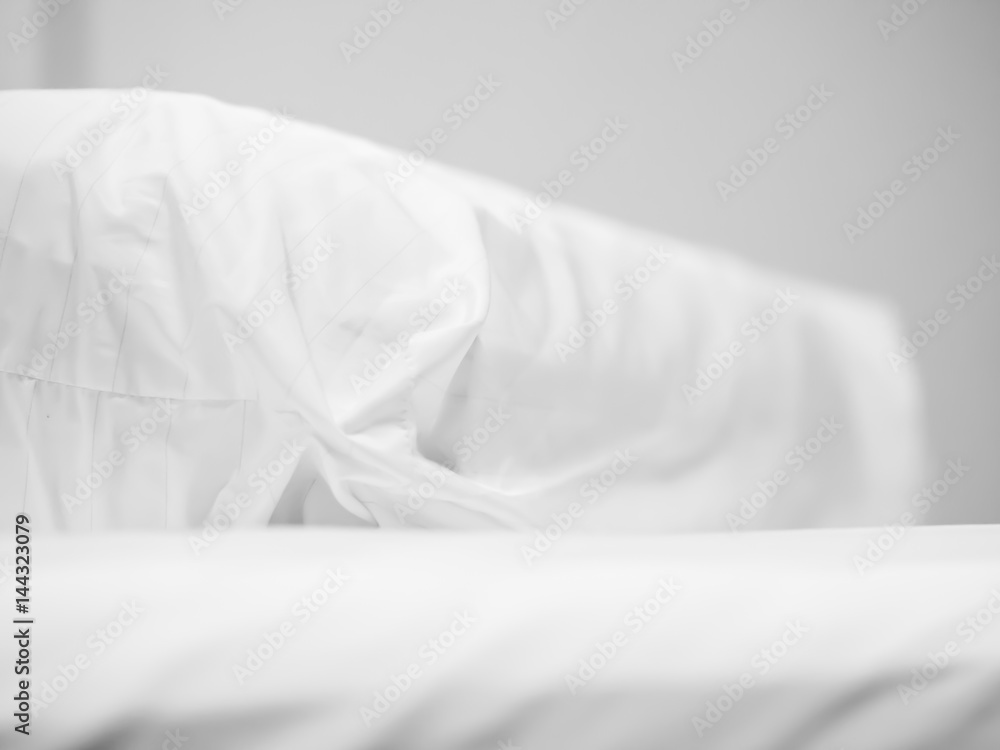 Closeup of white bolster on bed in bedroom.