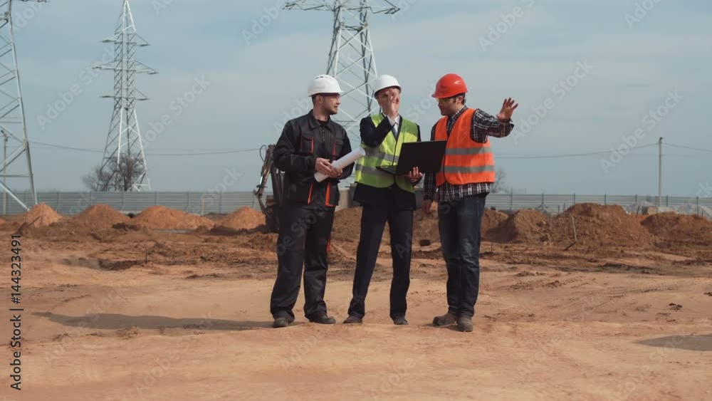 The engineer, architect and builder standing and talking on a construction site. The engineer, architect and builder standing and talking on a construction site.