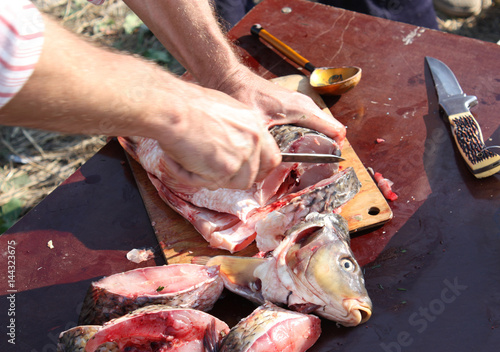 Cutting fish with a knife into pieces