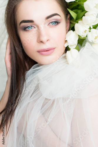 Portrait of a girl with blue eyes. Flowers in a hairdress