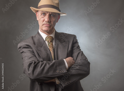Konstfotografi Mature man dressed as a 1940s gangster, on a grey smoky background