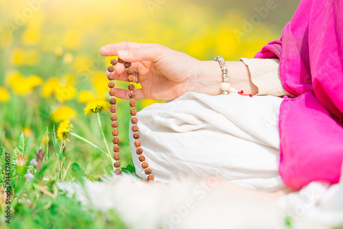 Woman reads the yoga mantra during practice with the mala
