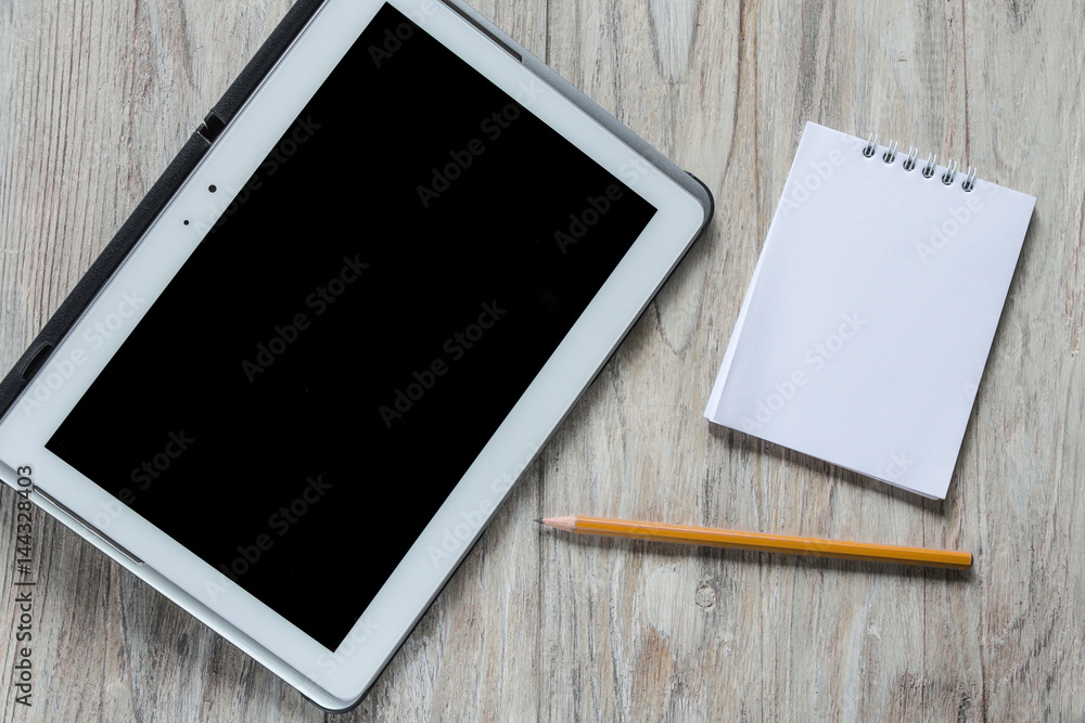 Tablet, notebook and pencil on wooden background Tablet, notebook and pencil on wooden background
