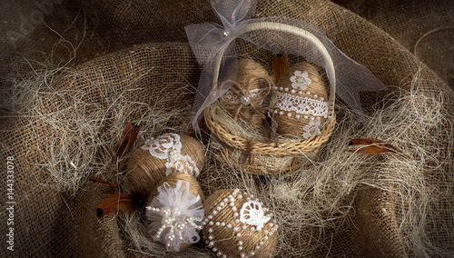 Easter eggs on a background of burlap,decorated with beads,twine