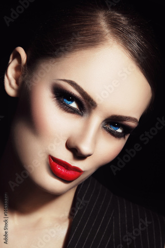 Young beautiful woman with smoky eyes and red lipstick