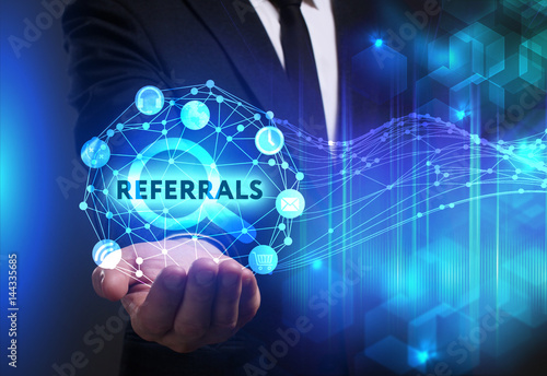 Business, Technology, Internet and network concept. Young businessman working on a virtual screen of the future and sees the inscription: Referrals