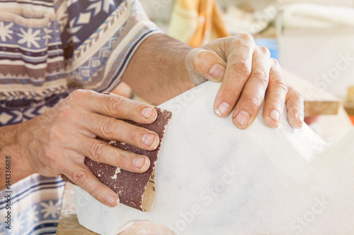 artist sanded piece of white marble in the studio