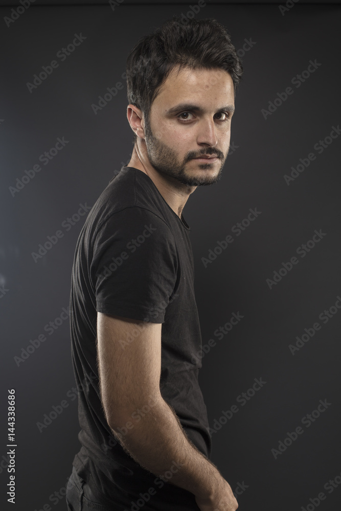 Caucasian guy wearing black T-shirt in studio 