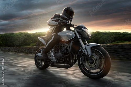 Motorrad auf Landstra  e bei Sonnenuntergang