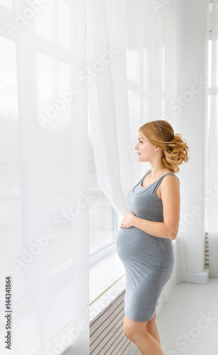 pregnancy, motherhood, people and expectation concept - close up of happy pregnant woman opening window curtains Free Download pregnancy, motherhood, people and expectation concept - close up of happy pregnant woman opening window curtains - GFXLoad