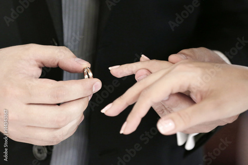 dettaglio mani del momento dello scambio degli anelli tra due sposi