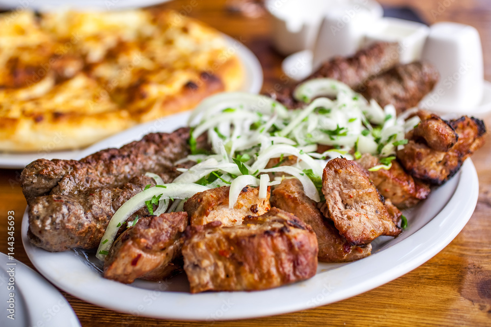Traditional Georgian mtsvadi pork barbecue and Kebab with onion and parsley Traditional Georgian mtsvadi pork barbecue and Kebab with onion and parsley