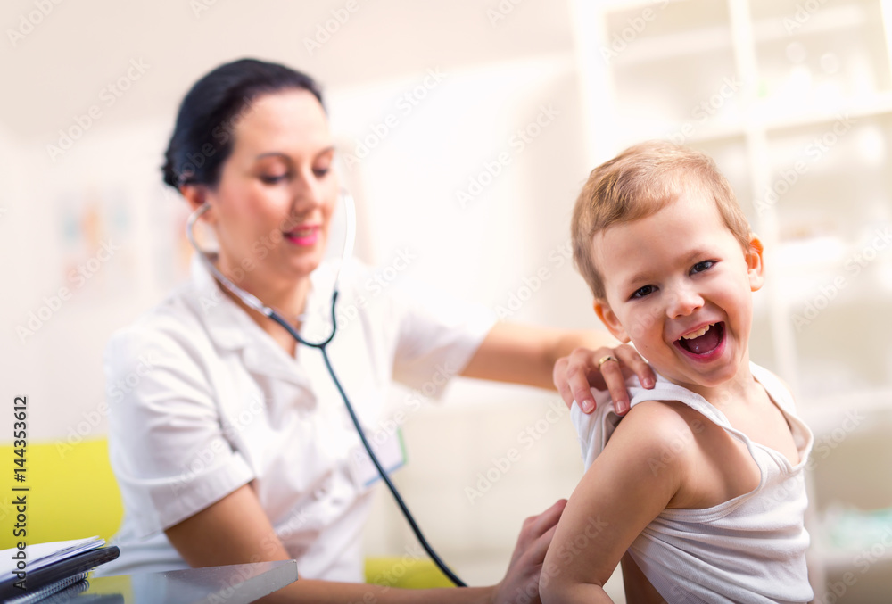 Happy little boy at the doctor for a checkup - being examined with a stethoscope Happy little boy at the doctor for a checkup - being examined with a stethoscope