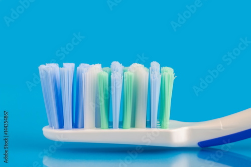 Toothbrush head on blue background, macro image.