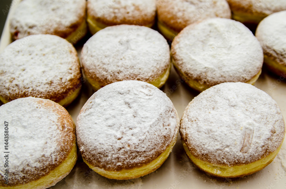 Naklejka premium Donuts sprinkled with powdered sugar.