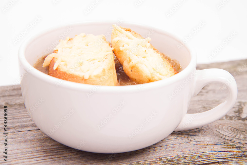 Onion soup with toast on a wooden background Onion soup with toast on a wooden background