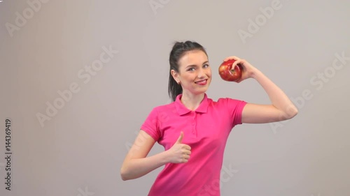 Healthy eating, vegetarian food, dieting and power concept. Young woman young fit female long haired colorful make up holds big red apple fruit