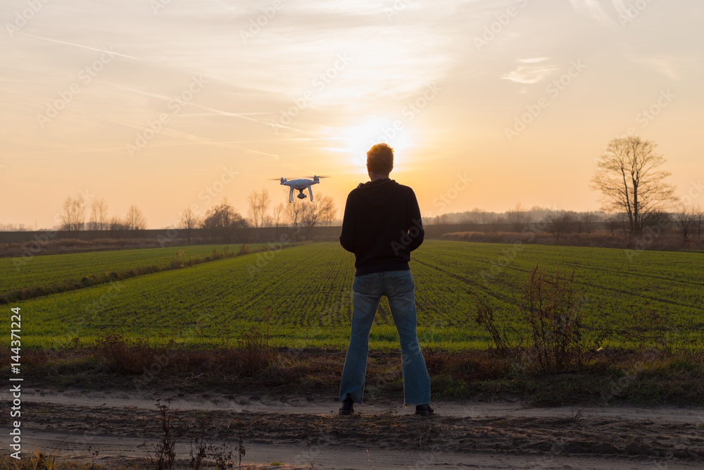 Men with drone flying at sunset