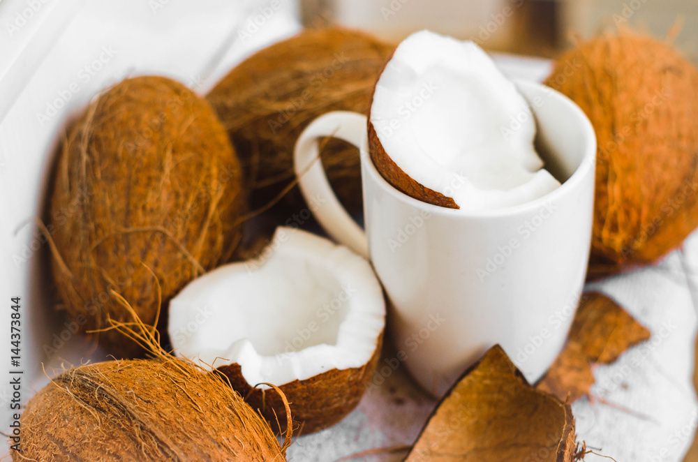 Tasty cocktail in white cup with coconut on table .