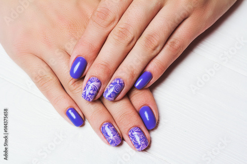 Purple nail art with pink floral pattern