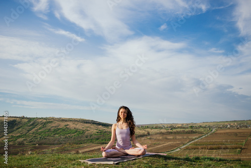 Wallpaper Mural Young woman doing complex Yoga exercise on a rock Torontodigital.ca
