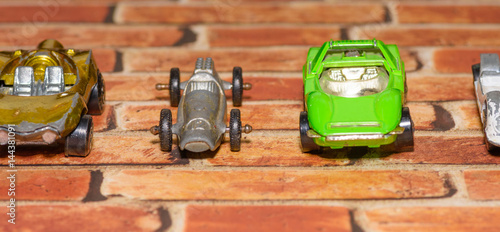 Vintage toy cars in line on brick background