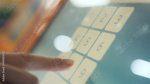 Atm machine close up hand entering pin number. Close up of the hand of woman pushing buttons for money cah in out, entering the pin number at the atm machine. photo