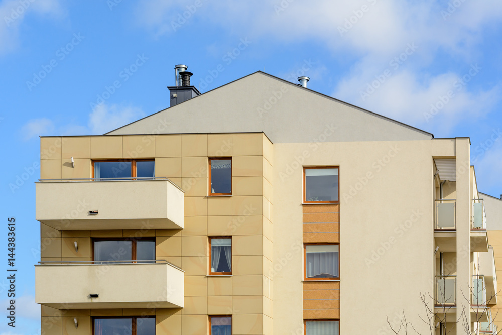 Modern apartment block with balcony against a blue sky. Modern apartment block with balcony against a blue sky.