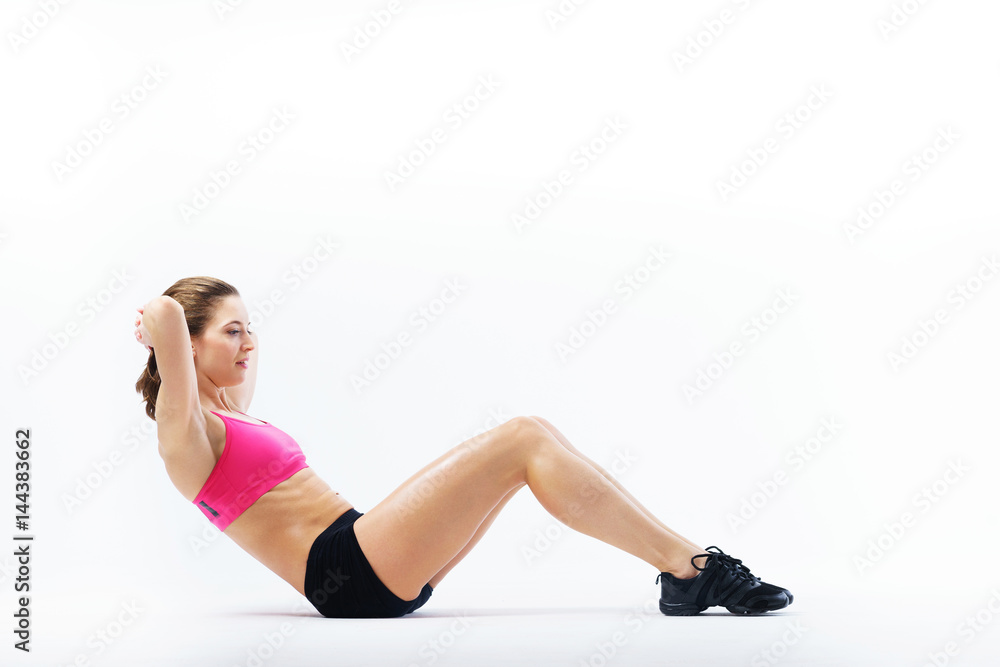 Young attractive tanned slender girl performs sports exercises. Young attractive tanned slender girl performs sports exercises.