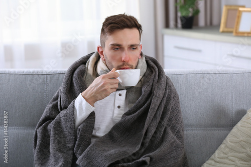 Ill man in blanket drinking...