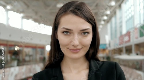 Happy exotic woman shopping at the mall, close portrait of confident smiling business woman in store or airport terminal, consultant, shop assistant photo