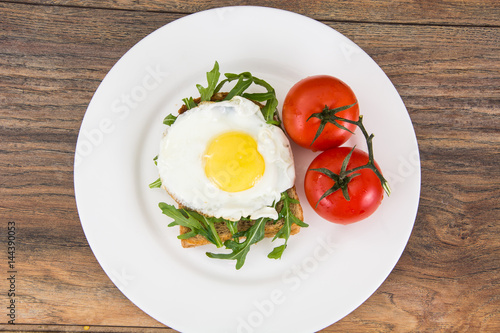 Breakfast toast with fried egg and arugula