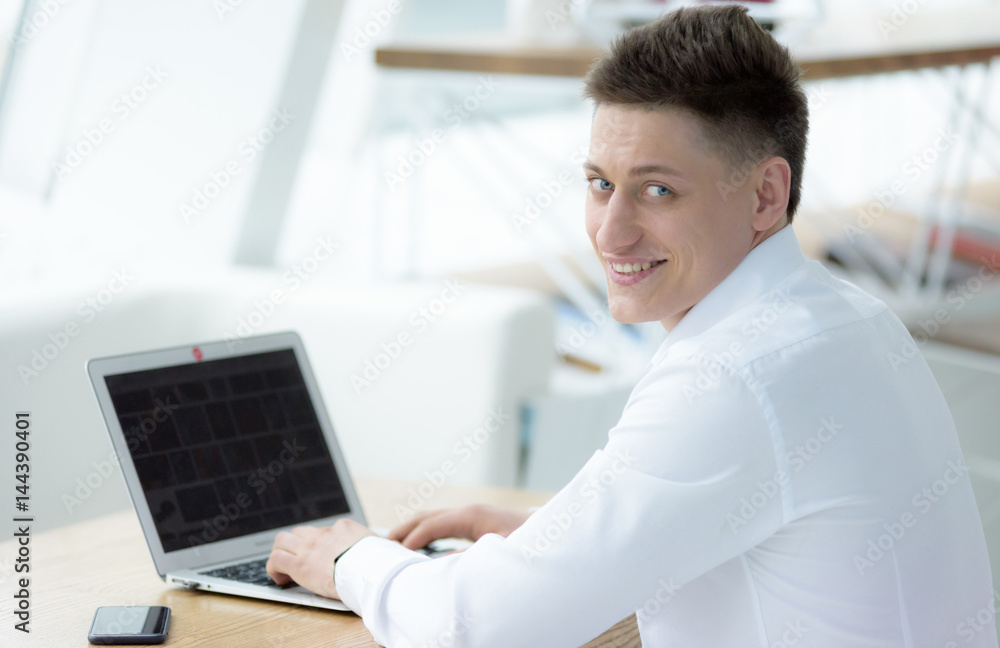 Stylish middle-aged businessman looking at camera with toothy smile while working on project in cozy small cafe, portrait
