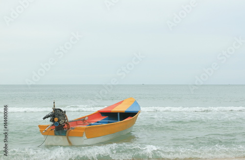 Long Tail Steel Boat with Colorful Strip - Red, Yellow, Blue, Alone Against the Pale Blue Sea and Sky, Southern of Thailand © wibulpas
