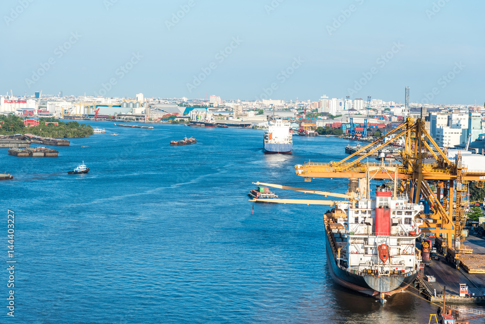 Logistics and transportation of Container Cargo ship and Cargo plane with working crane bridge in shipyard at blue sky, logistic import export and transport industry background