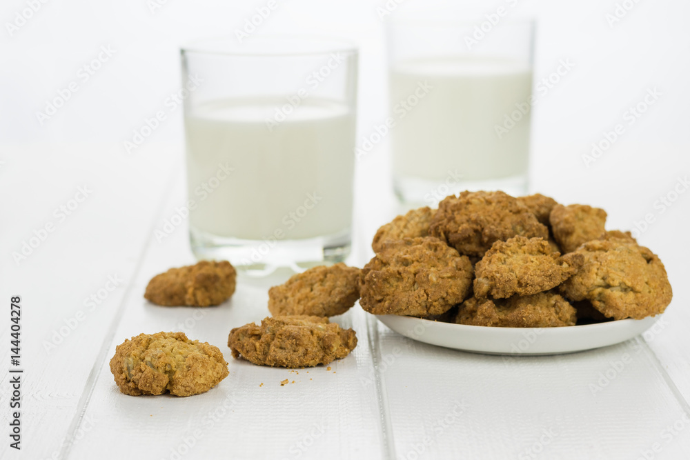 Milk in two glasses and bowl with homemade biscuits. Milk in two glasses and bowl with homemade biscuits.