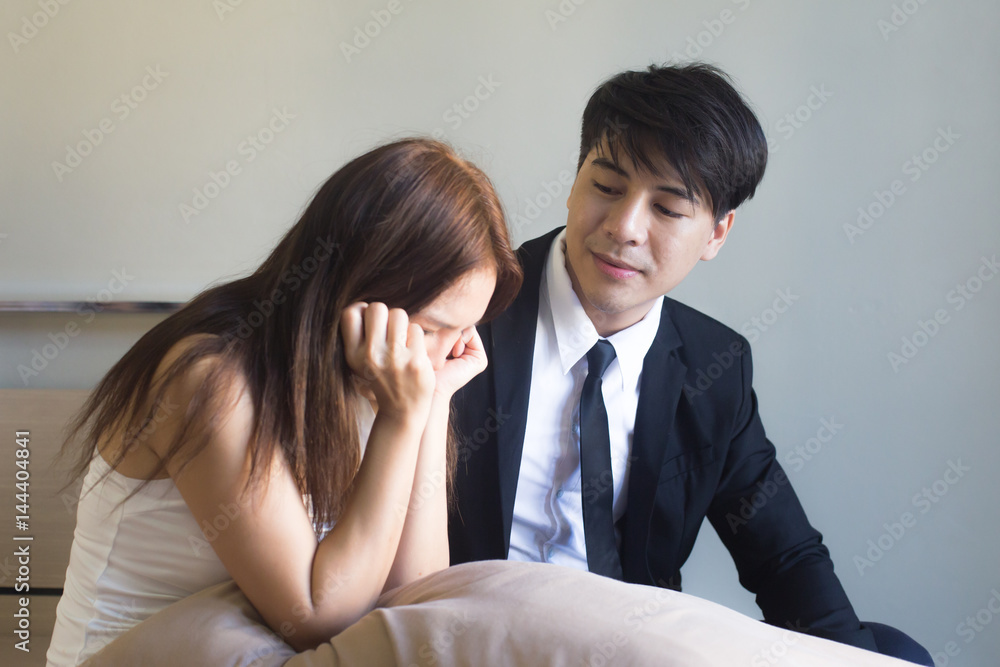 Young asian couple having a quarrel in room, Girl is crying while her boyfriend is calming her Young asian couple having a quarrel in room, Girl is crying while her boyfriend is calming her