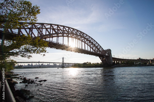 Fototapeta Naklejka Na Ścianę i Meble -  The Hell Gate Bridge and the Triborough bridge over the river with blue sky, Astoria park, New York