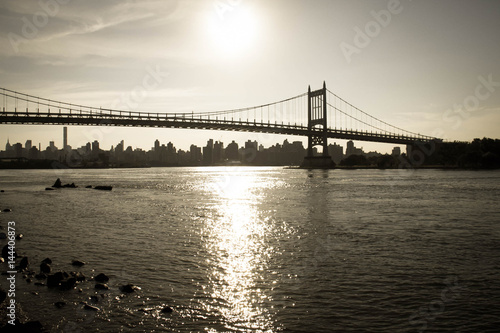 Silhouette of Triborough bridge over the river and the city in vintage style, New York