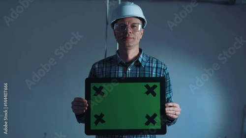 Adult taskmaster holding a frame for copy space in the construction site.