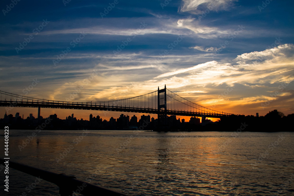 Triborough bridge, fence and city with cloudy sunset sky, New York Triborough bridge, fence and city with cloudy sunset sky, New York