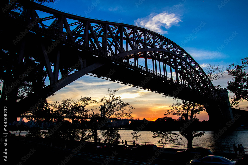 Naklejka premium Hell Gate Bridge and in silhouette with sunset sky, New York