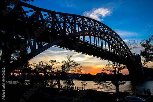 Hell Gate Bridge and in silhouette with sunset sky, New York