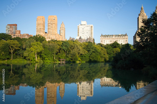 Reflection of buildings in the lake at Central Park with blue sky