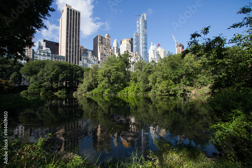 Reflective lake under the shade and buildings in Manhattan, New York